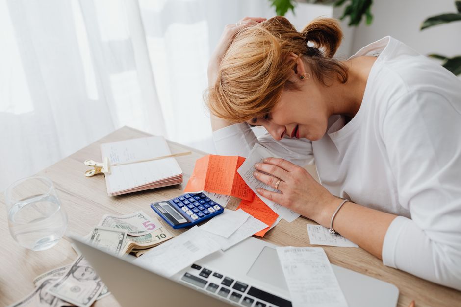 pexels-5900136-payoneer-monthly-statement-completed-vat-ledger 女士在电脑旁核对收据与计算器